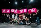 Grupa programistów trzyma różowy napis "Hackathon"