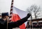 Strażacy wciągają flagę Polski na maszt.