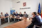 Uczestnicy wydarzenia siedzą w sali konferencyjnej. Na ścianie widoczny napis Małopolska.