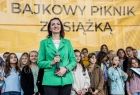 Marta Malec-Lech z zarządu województwa przemawia do uczestników wydarzenia. Z tyłu widoczne dzieci i napis Bajkowy piknik z książką.