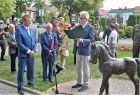 Uroczystość odsłonięcia pomnika konia Kasztanka. Przy mikrofonie stoi mężczyzna, obok inni ludzie.