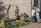 Ludzie oglądają stoisko grupy rekonstrukcji historycznej.