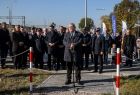 Minister Andrzej Adamczyk przemawia na parkingu przy dworcu. Z tyłu widoczni ludzie.