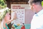 Wicemarszałek Łukasz Smółka ogląda mapę z napisem Jurajski Szlak Winny. Obok stoi kobieta.