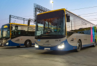 Nowoczesne autobusy Iveco w barwach Małopolski stoją na dworcu kolejowym.