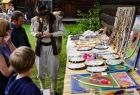 stoisko z rękodziełem, twórca ludowy podczas rozmowy z odwiedzającymi