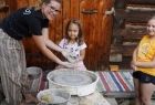 dziewczynka za kołem garncarskim wraz z instruktorką prezentuje swoją pracę z gliny