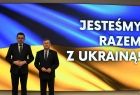 marszałek Małopolski i wojewoda na tle flagi Ukrainy. w tle napis "Jesteśmy razem z Ukrainą"