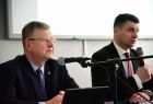 Marszałek Witold Kozłowski i wicemarszałek Łukasz Smółka siedzą przy stole z mikrofonami.