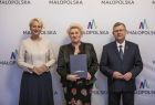 marszałek Witold Kozłowski i Iwona Gibas z zarządu z przedstawicielem Małopolskiej Rady Pożytku Publicznego, w tle ścianka z logo Małopolski