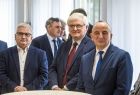 Wicemarszałek Józef Gawron stoi w towarzystwie mężczyzn.