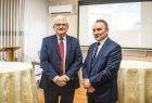 Wicemarszałek Józef Gawron stoi na sali konferencyjnej w towarzystwie mężczyzny.