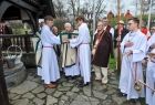 Proboszcz, księża i lektorzy wokół nich widać baców ubranych w tradycyjne stroje z lewej strony widać zamknięta studnie. 