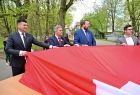 Wicemarszałek Łukasz Smółka trzyma flagę RP