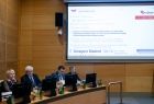 Marszałek Witold Kozłowski, wojewoda Łukasz Kmita, wicemarszałek Józef Gawron, wicemarszałek Iwona Gibas, w trakcie obrad sejmiku województwa małopolskiego. W prawy górnym rogu widać tablice multimedialna w zaświetlonymi wynikami głosowania. 
