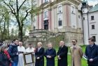  Dziedziniec zakonu Paulinów na krakowskiej Skałce, w tle widać mury zakonne. Na pierwszym planie, marszałek Witold kozłowski, prof. Jan Tadeusz Duda i wicemarszałek Iwona Gibas, przekazują zakonnika, pamiątkowy list intencyjny. 