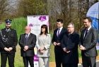 Uczestnicy wydarzenia słuchają przemówień. W tle zieleń.
