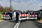 Ludzie otwierają barierki na drodze.