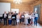 Iwona Gibas i Rafał Kosowski z grupą beneficjentów na tle ścianki