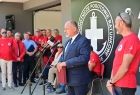 Prezes WFOŚiGW podczas wystąpienia, za nim stoją ratownicy WOPR