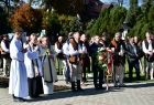 Widok na: Marszałek Małopolski Witold Kozłowski z kwiatami po lewej księża biorący udział w uroczystości