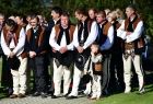 Górale w strojach regionalnych biorących udział w uroczystości w Ludźmierzu stojący na zewnątrz