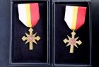 Widok na dwa medale w kształcie krzyża. Medale znajdują się w granatowym futerale. 