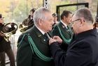Marszałek Witold Kozłowski, wręcza odznaczenia, mężczyźnie w zielonym stroju galowym.