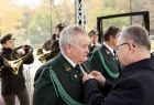 Marszałek Witold Kozłowski, wręcza odznaczenia, mężczyźnie w zielonym stroju galowym. W tle widać dwóch trębaczy. 