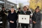 Widok na mężczyzne trzymającego Medal Polonia Minor, Po jego prawej stronie stoi marszałek Witold Kozłowski po lewej radna Marta Mordarska. 