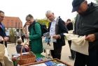 Grupa osób przegląda foldery promocyjne, w tle widok na kamieniczki