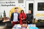 Stoisko promocyjne Małopolski, na drugim planie grupa osób stoi przed kamperem Małopolski