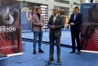 Na konferencji prasowej stoi trzech mężczyzn. Obok widoczne banery Igrzysk Europejskich 2023.