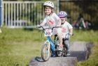 Zdjęcie przedstawia dwójkę dzieci na rowerkach uczestniczących w Małopolska Tour w 2021