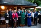 Wspólne pamiątkowe zdjęcie przedstawicieli Zarządu Województwa Małopolskiego, radnych województwa i pracowników przedstawicielstwa w Brukseli na tle drewnianej altany