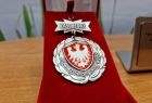 Medal Zasłużony dla Stowarzyszenia Ofiar Wojny w pudełku.