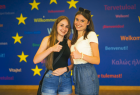 Dwie dziewczyny na tle baneru Unii Europejskiej. 