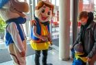 Dwie osoby przebrane za maskotki w strojach regionalnych witające dzieci i rodziców przed wejściem do Centrum Sztuki Mościce