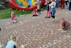 Dziewczynka pisze kredą na chodniku "Małopolski Zielony Tydzień 2022"