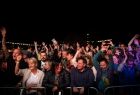 Widok na tłum ludzi bawiących się pod sceną na koncercie. 