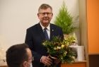 Marszałek Witold Kozłowski trzyma w rękach kwiaty. Sala nowego przedszkola w Sękowej, W tle widać pomarańczowe przedszkolne szafki. 