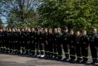 Członkowie młodzieżowej drużyny pożarniczej OSP Bór stojący w szeregu na placu przed strażacką remizą podczas spotkania z okazji Dnia Dziecka