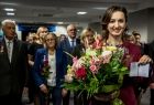 Marta Malec-Lech z zarządu województwa stoi uśmiechnięta. W dłoniach trzyma duży bukiet kwiatów.