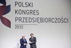 Wicemarszałek Józef Gawron z jednym z laureatów na tle banneru z napisem "Polski Kongres Przedsiębiorczości"