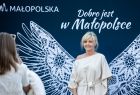 Kobieta na tle skrzydeł z napisem Dobro jest w Małopolsce.