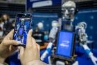uczeń robi zdjęcie smartfonem robota na stoiku informatycznym