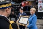 Iwona Gibas z zarządu województwa i Rafał Kosowski - radny województwa prezentują przyznany straży Medal Polonia Minor