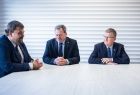 Wójt Moszczenicy, poseł Patryk Wicher i marszałek Witold Kozłowski, siedzą przy białym stole. 