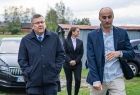 Marszałek Witold Kozłowski idzie w towarzystwie mężczyzny przez podwórko. 