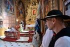 Widok na ołtarz w kościele w Ludźmierzu oraz wypowiadającego się w baranicy górala po prawej poczet sztandarowy